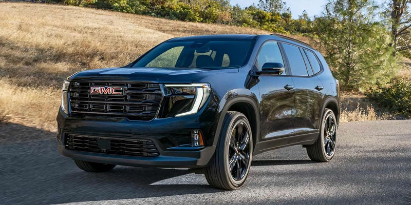 Black 2026 GMC Acadia parked on a scenic road