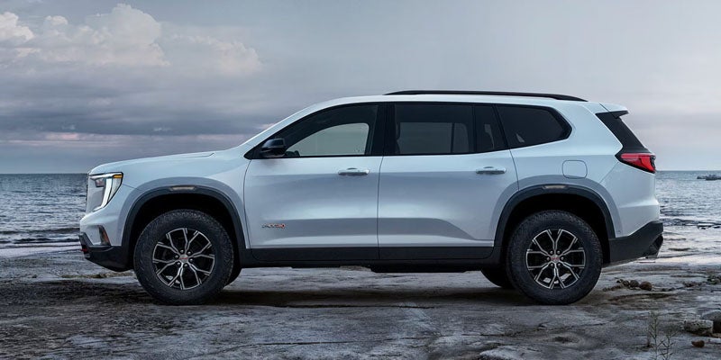 White 2026 GMC Acadia parked by the waterfront.