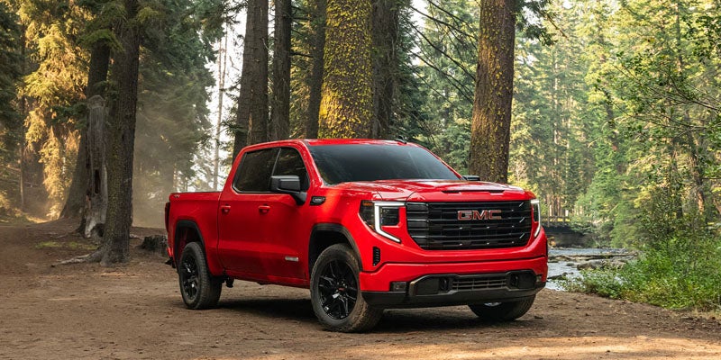 Red GMC Sierra 1500 exterior in a forest setting