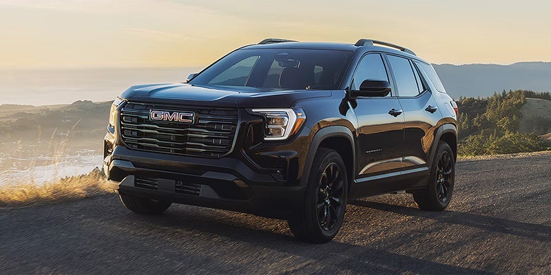 Black 2026 GMC Terrain parked on a scenic road.